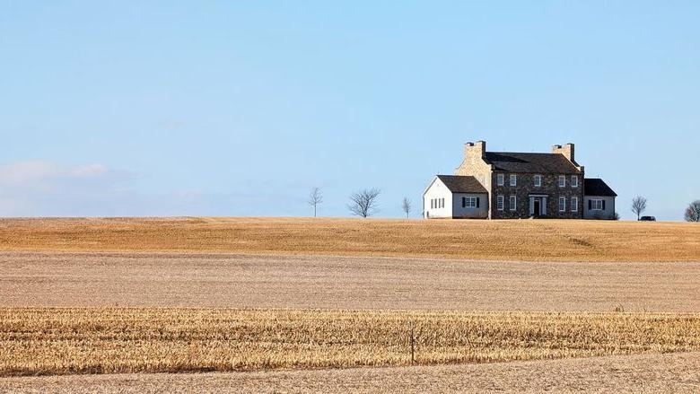 An old farmhouse in the middle of a field